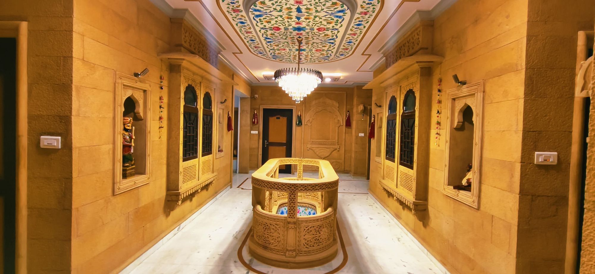 Sandstone atrium at Hotel Moonlight with carved jharokhas and a painted ceiling